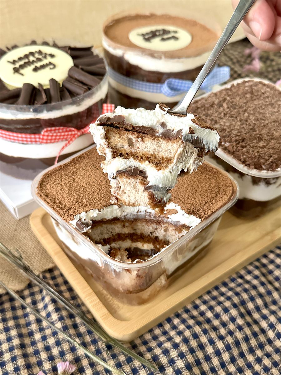 Tiramisu dessert box — creamy layers lifted on a spoon