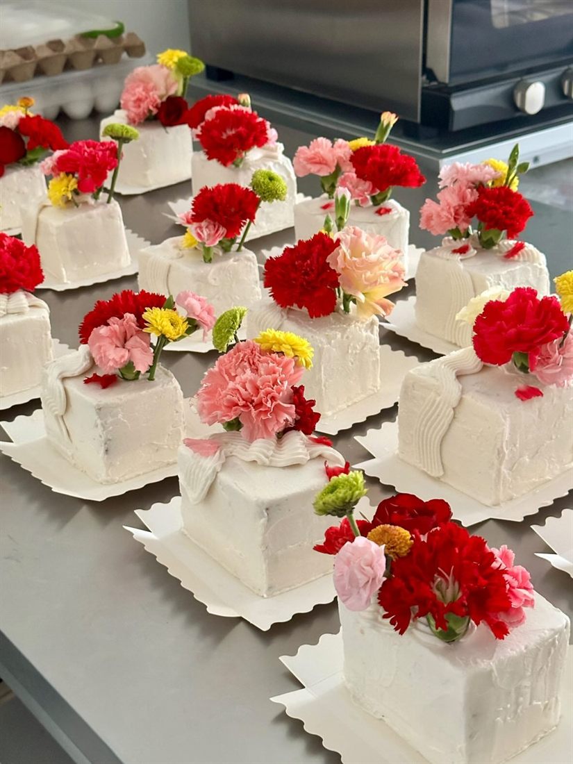 A fresh batch of mini slab cakes on scalloped boards in the Sugarcoat kitchen