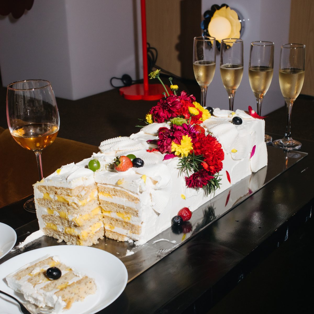 A Sugarcoat slab cake — layered chiffon with cream and custard, crowned with real flowers and berries