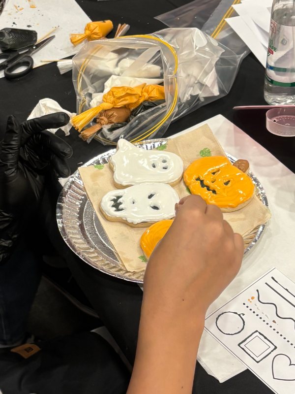 Piping icing onto a ghost cookie — close-up from the same session